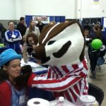 At the Madison Kids Expo 2015, face painter Trudy getting her face painted by Bucky Badger
