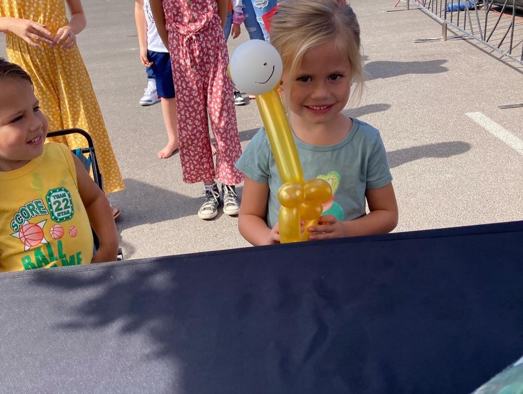 Cute young girl with a balloon animal giraffe at Fall Fest
